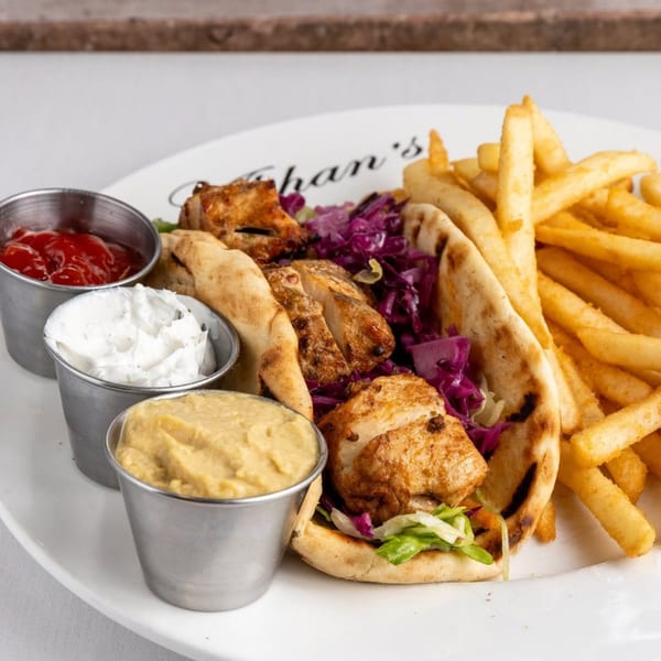 Alihan's Mediterranean Cuisine chicken pita with red cabbage, lettuce, fries, ketchup, tzatziki, and hummus.