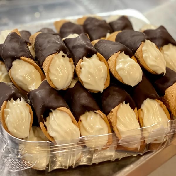 A tray of chocolate-dipped cannolis with creamy white filling, ready to be served at Alihan's Mediterranean Cuisine.