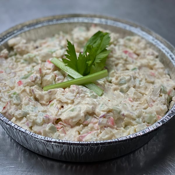 Creamy Mediterranean salad with celery and red peppers in a foil container.