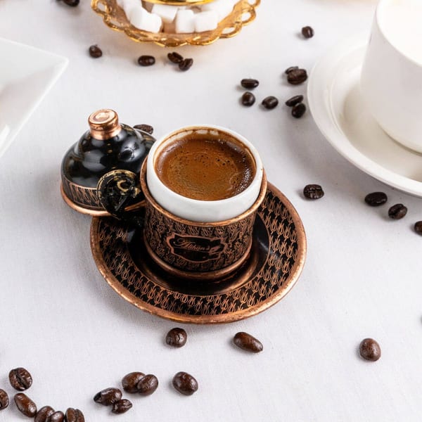 Alihan's Mediterranean Cuisine Turkish coffee in an ornate copper cup with coffee beans and sugar cubes.